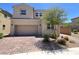 Charming two-story home showcasing neutral stucco, brick driveway, and a well-manicured front yard at 2125 Stone Well Rd, North Las Vegas, NV 89031