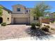 Beautiful home exterior with desert landscaping, brick driveway, and a two-car garage at 2125 Stone Well Rd, North Las Vegas, NV 89031