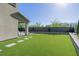 Large backyard featuring artificial turf, a covered patio, and tasteful landscaping at 2151 Noble Perch St, Las Vegas, NV 89138