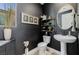 Stylish powder room featuring dark walls, decorative fixtures, and modern vanity at 2151 Noble Perch St, Las Vegas, NV 89138