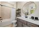Modern bathroom with gold accents, a shower-tub combo, and a large mirror at 2151 Noble Perch St, Las Vegas, NV 89138
