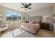 A bright bedroom features a large window offering picturesque mountain views and a stylish ceiling fan at 2151 Noble Perch St, Las Vegas, NV 89138