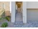 Home featuring a welcoming front entrance with stairs, neutral stucco, and desert landscaping at 2151 Noble Perch St, Las Vegas, NV 89138