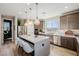 Bright kitchen boasts quartz countertops, stainless steel appliances, and a center island with bar seating at 2151 Noble Perch St, Las Vegas, NV 89138