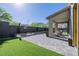 Inviting patio with artificial turf, stone pavers, and a comfortable seating area at 2151 Noble Perch St, Las Vegas, NV 89138