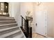 Carpeted staircase with dark wood railing leading to the upper level and front door at 2151 Noble Perch St, Las Vegas, NV 89138