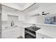 Bright kitchen features white cabinetry, modern appliances, quartz countertops, and views to adjacent living area at 2480 Old Forge Ln # 74, Las Vegas, NV 89121