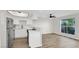 Open-concept living area with wood floors, white walls, and modern kitchen at 2480 Old Forge Ln # 74, Las Vegas, NV 89121