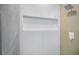 Tiled shower featuring a shower niche, a rainfall shower head and sleek fixtures at 2561 Terrytown Ave, Henderson, NV 89052