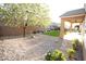 Beautiful backyard featuring desert landscaping, artificial lawn, and a mature flowering tree at 2623 Red Planet St, Henderson, NV 89044