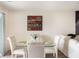 Bright dining area featuring a glass table, upholstered chairs, and modern wall decor, complemented by natural light at 2629 Mocha Pearl Ct, North Las Vegas, NV 89086