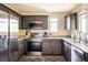 Modern kitchen featuring stainless steel appliances, dark cabinets, and granite countertops at 2629 Mocha Pearl Ct, North Las Vegas, NV 89086