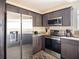Modern kitchen featuring stainless steel appliances, dark cabinets, and granite countertops at 2629 Mocha Pearl Ct, North Las Vegas, NV 89086