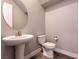 Powder bathroom features a pedestal sink, toilet, and round mirror at 2680 Nevada Agave Ln, Las Vegas, NV 89138