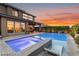 Illuminated backyard pool and spa at dusk, with outdoor lounge seating, set against a colorful sky at 2680 Nevada Agave Ln, Las Vegas, NV 89138