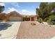A single-story home featuring xeriscaping, a terra cotta tile roof, and an attached garage at 2925 Lotus Hill Dr, Las Vegas, NV 89134