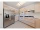 Modern kitchen with stainless steel refrigerator, white cabinets, and a sleek gas cooktop at 2925 Lotus Hill Dr, Las Vegas, NV 89134
