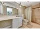 This well-lit bathroom features a glass enclosed shower, single sink vanity, and a neutral color palette at 3141 E Katie Ave, Las Vegas, NV 89121