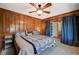 Spacious bedroom featuring wood paneling, and a ceiling fan and access to a closet at 3141 E Katie Ave, Las Vegas, NV 89121