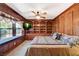 Bedroom featuring wood paneling, ceiling fan, and built-in bookshelves and a window seat at 3141 E Katie Ave, Las Vegas, NV 89121