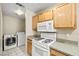 Well-lit kitchen includes a gas range, microwave, and adjacent laundry area with full-size washer and dryer at 3464 Twilight Star Dr, Las Vegas, NV 89117