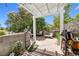 Cozy outdoor patio with a charming pergola, lush greenery, and a stone accent wall at 3464 Twilight Star Dr, Las Vegas, NV 89117