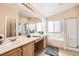 Bright bathroom with double vanity, separate shower, and tub with natural light from a large window at 3539 Barrel Bronco Ct, North Las Vegas, NV 89032