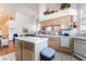 Open kitchen featuring white appliances, tile countertops, light wood cabinets, and an island at 3646 Billman Ave, Las Vegas, NV 89121