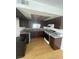 Well-lit kitchen featuring dark cabinets, light countertops, laminate floors, and stainless steel appliances at 4363 Spencer St # 8, Las Vegas, NV 89119