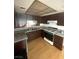 Well-lit kitchen featuring dark cabinets, light countertops, laminate floors, and stainless steel appliances at 4363 Spencer St # 8, Las Vegas, NV 89119