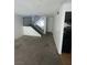 View of the living room and staircase featuring gray carpet and white walls at 4363 Spencer St # 8, Las Vegas, NV 89119