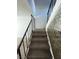 Carpeted staircase featuring a decorative wall and black metal railing at 4363 Spencer St # 8, Las Vegas, NV 89119