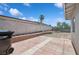A spacious backyard featuring a tiled patio and block wall, offering privacy and a blank canvas for landscaping at 460 Crestway Rd, Henderson, NV 89015