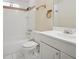 Functional bathroom with white tiled shower and bath, a single sink, and a toilet at 460 Crestway Rd, Henderson, NV 89015