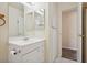 Functional bathroom featuring a single sink vanity, white tile, and an open doorway at 460 Crestway Rd, Henderson, NV 89015