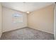 A simply decorated bedroom with neutral walls, plush carpeting, and a window with blinds at 460 Crestway Rd, Henderson, NV 89015
