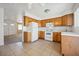 Bright kitchen features wood cabinetry, white appliances, and tile flooring for a functional cooking space at 460 Crestway Rd, Henderson, NV 89015