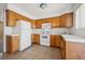 Bright kitchen features wood cabinetry, white appliances, and tile flooring for a functional cooking space at 460 Crestway Rd, Henderson, NV 89015