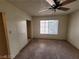 Neutral bedroom with a ceiling fan, soft carpet flooring, sliding closet door, and a sunlit window at 4795 Via San Andros, Las Vegas, NV 89103