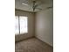 Bright bedroom featuring neutral carpet, ceiling fan, and a sunlit window at 4795 Via San Andros, Las Vegas, NV 89103