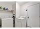 Bright laundry room features washer, dryer, shelving, and white walls at 5016 Jacarilla Ln, North Las Vegas, NV 89031
