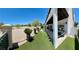 Backyard featuring artificial turf, landscaping, and covered patio with views of the golf course at 5041 Portraits Pl, Las Vegas, NV 89149