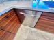 Modern kitchen features a stainless steel dishwasher with wood cabinets and marble countertops and flooring at 5041 Portraits Pl, Las Vegas, NV 89149