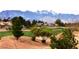 Scenic view of the golf course with desert landscaping, mountain backdrop, and well-maintained greens at 5041 Portraits Pl, Las Vegas, NV 89149