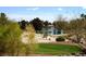 Picturesque view of golf course with a pond surrounded by lush greenery and desert landscape, showcasing the community's beauty at 5041 Portraits Pl, Las Vegas, NV 89149