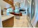 This modern kitchen offers stainless appliances, wood cabinets, and an island cooktop with breakfast bar that opens to the living area at 5041 Portraits Pl, Las Vegas, NV 89149