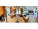 This updated kitchen features wood cabinets, stainless appliances, and center cooktop island opening to the living and dining areas at 5041 Portraits Pl, Las Vegas, NV 89149