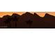 Dramatic silhouette of mountain range and palm trees at sunset, capturing a serene desert landscape at 5041 Portraits Pl, Las Vegas, NV 89149