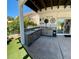 Covered outdoor kitchen with stainless steel appliances, tiled countertop, and easy access from the interior via sliding glass doors at 5041 Portraits Pl, Las Vegas, NV 89149