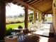 Inviting covered patio with tables, chairs, and picturesque golf course views at 5041 Portraits Pl, Las Vegas, NV 89149